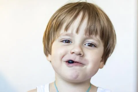 The boy eats a delicious berry and holds it in the palm of his hand. The plea Stock Photos