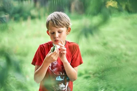 Boy eats delicious snack with vegetables in country house Foto stock
