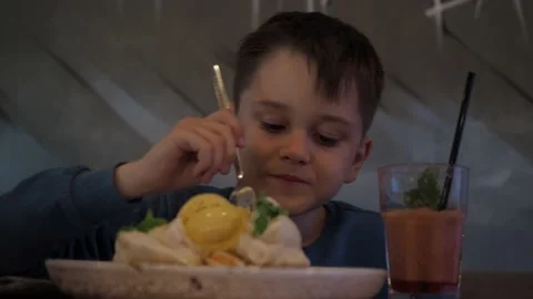 A boy eats dessert in a cafe. waffles with cream and smoothies in a glass. a Stock Footage 154895689