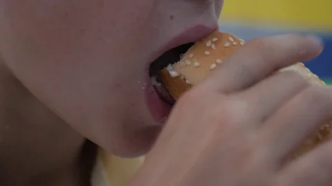 The boy eats at a fast food cafe. Harmful and tasty food Stock Footage 94754277