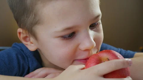 Boy eats fruits. Ripe red apple Stock Footage 295003589