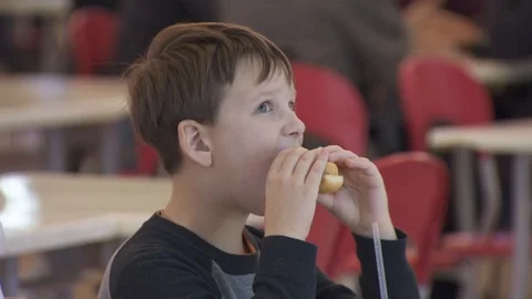 Boy eats a hamburger. close-up. food court in the mall Video stock 113801446