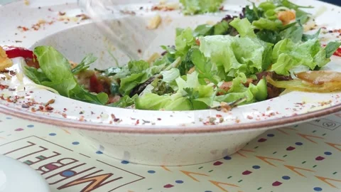 Boy eats healthy lunch of green salad with vegetables and nuts in a cafe Stock Footage 271089815