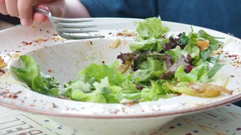 Boy eats healthy lunch of green salad with vegetables and nuts in a cafe Stock Footage 271090084