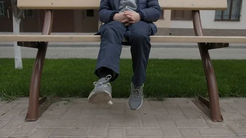 Boy eats Lollipop and shakes her legs on the bench near the house Stock Footage 130117988