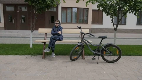 Boy eats Lollipop. Rejoices, smiles, licks the candy, fools around. Gray Bike Stock Footage 130117992