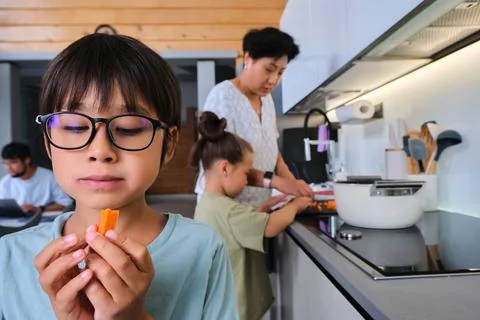 A boy eats a piece of carrot. Stock Photos