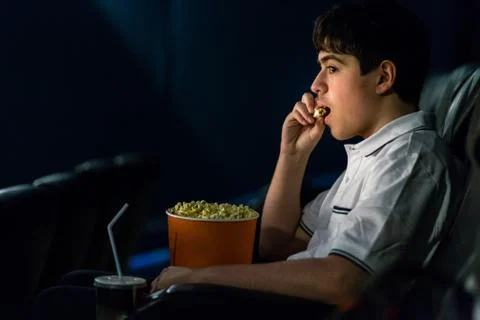 Boy eats popcorn  at the cinema Stock Photos
