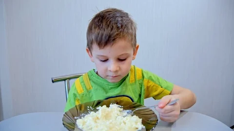 Boy eats porridge from a plate Stock-Footage 73128618