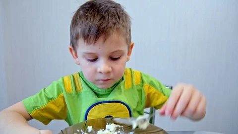 Boy eats porridge from a plate Video stock 73128999
