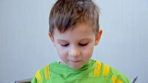 Boy eats porridge from a plate Stock Footage 73129182