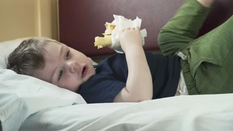 Boy eats shawarma on the shelf of the car 스톡 동영상 134607446