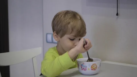 The boy eats soup at the table Stock Footage 98788722