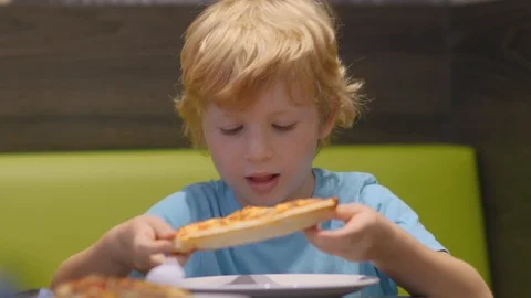 Boy Eats Tasty Pizza Piece In Restaurant Stock Footage 93784245