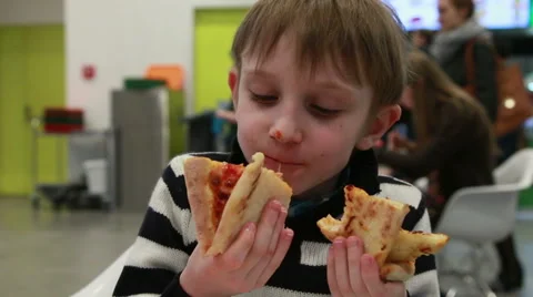 Boy eats two slices of pizza at once Stock Footage 52462102