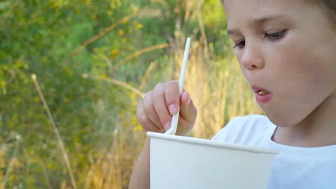 A boy eats a vegetable salad at a picnic. Face close-up. Stock Footage 311995342