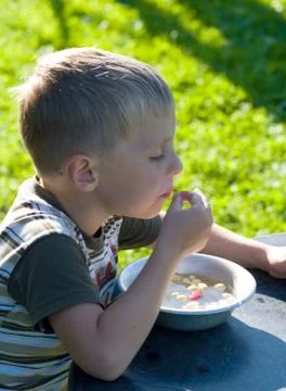 The boy eats wild strawberry. Stock Photos