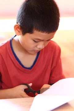 Boy Engaged in Creative Paper Cutting Activity Stock Photos