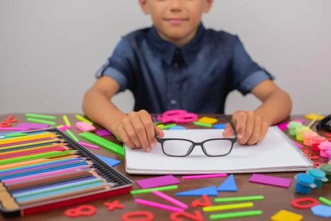 Boy engaged creativity at table draws poor eyesight glasses selective focus Stock Photos