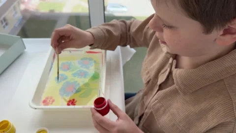 The boy is engaged in Ebru painting, with an array of tools Stock Footage 309939176
