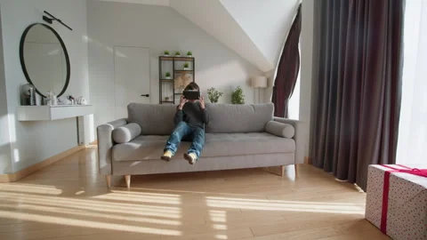 Boy Engaged in Virtual Reality. Excited child immersive gaming modern digital Stock Footage 335482301