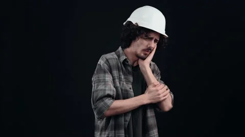 The boy with the engineer's white helmet feels an unbearable pain in his teeth Stock Footage 156277406