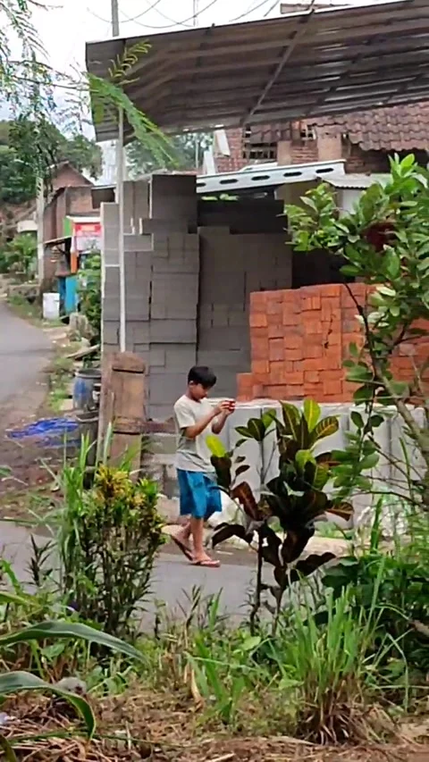 A boy is engrossed in playing smartphone while walking. Stock Footage 244849194