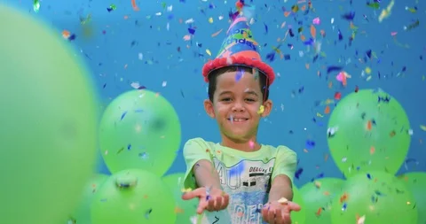Boy enjoying the confetti that falls down on him in slow motion Stock-Footage 96520236