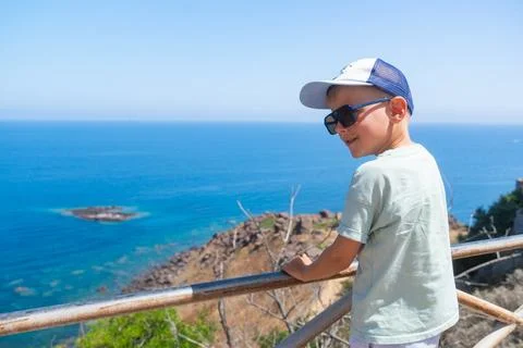 Boy Enjoying Scenic Ocean View from Coastline Lookout Foto stock