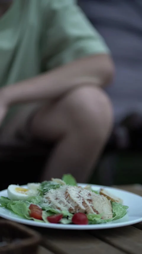 Boy enjoys classic Caesar salad topped with chicken and cheese Video stock 342968211