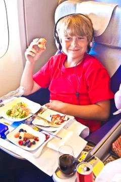 Boy enjoys the dinner in the aircraft Stock Photos