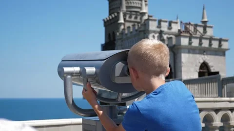 The boy enjoys the seascape, looking through binoculars on the observation deck. Stock Footage 331696567