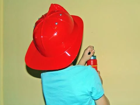 A boy equipped as a firefighter plays Stock Photos