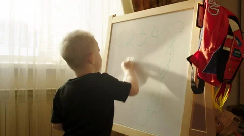 Boy Erasing Written from the Marker Board Stock Footage 60361057