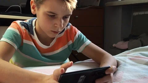 A boy of European appearance, 11 years old, plays telephone at home. Stock Footage 168902053