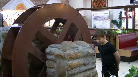 A boy examines a water mill 库存影片 62474671