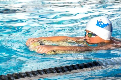 Boy exercising flutter kick with board. Stock Photos