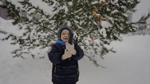 A boy exploding firecracker confetti on the street near the Christmas tree Stock Footage 169185995