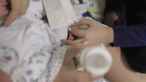 Boy exploring and playing with his newborn brother hand and fingers. Stock Footage 102581310