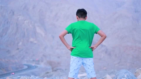 Boy express his tiredness in a mountain wearing in green dress Stock Footage 159659788