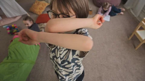 Boy in Eyeglasses Dancing and Laughing at Camera in Kindergarten Playroom Stock Footage 332322334