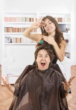 Boy with face expression with long hair at smiling female hairdresser Stock Photos