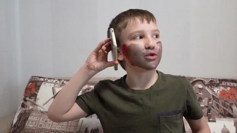 Boy with face paint talking on the phone, gesturing Video stock 127160141