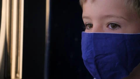 Boy in facemask is watching in the window from the train. Young traveler returns Stock Footage 138671783