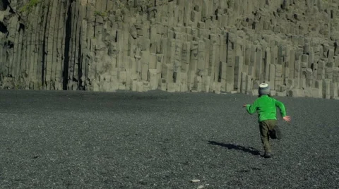 Boy falling down on Reynisfjara beach at south coast of Iceland, slow motion sho Vidéo 58664689