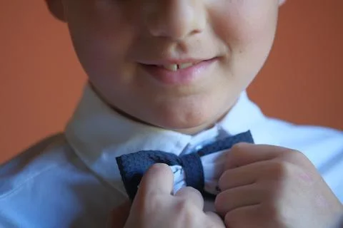 Boy fastens his bow tie at the first communion Stock Photos