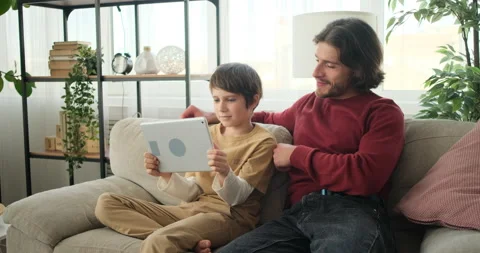 Boy with father playing on digital tablet Video stock 145232167