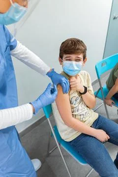Boy feeling pain while getting a vaccine. Stock Photos