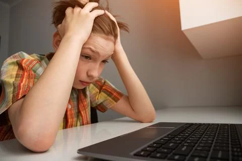 Boy feeling stressed while learning on laptop Stock Photos