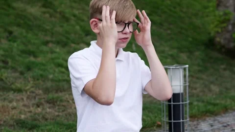 The boy feels a sharp headache while walking outside. Stock-Footage 288972750